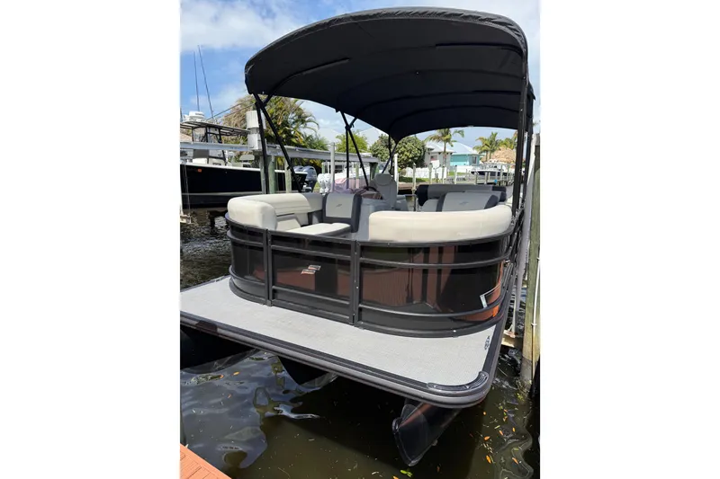 Slide: The Image of 2023 Starcraft EXS 3 Q pontoon boat docked, featuring spacious seating and canopy. - 2