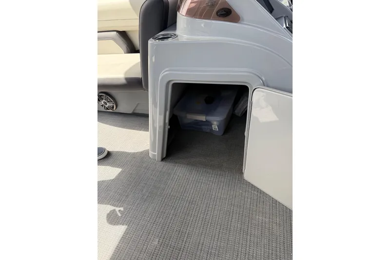 Slide: The Image of Storage compartment in 2023 Starcraft EXS 3 Q boat, featuring open door and interior view. - 23