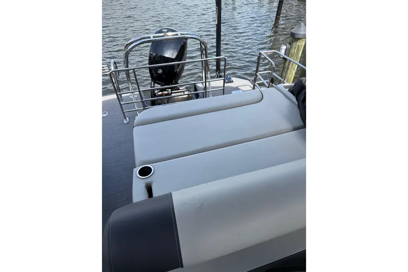 Slide: The Image of 2023 Starcraft EXS 3 Q boat with cushioned seating and outboard motor by the water. - 25