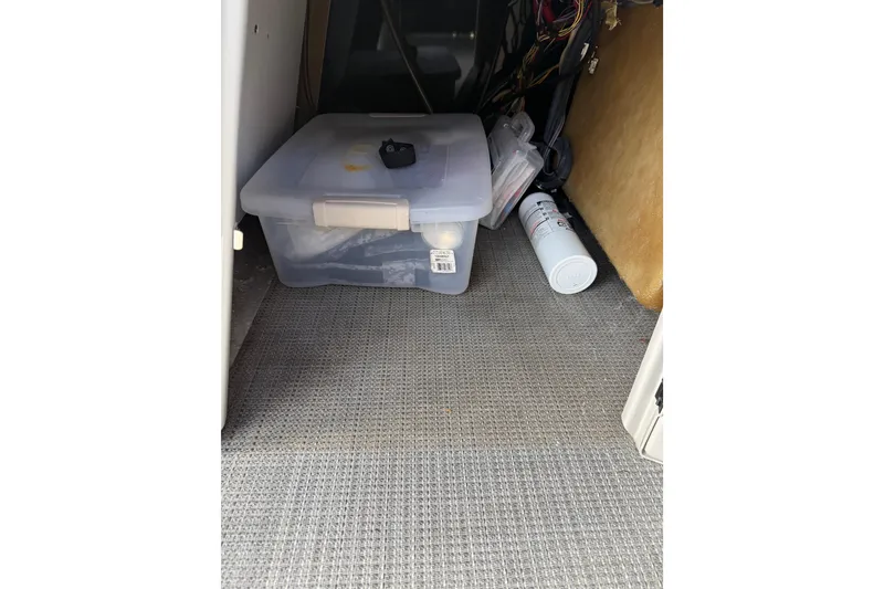 Slide: The Image of Storage compartment in 2023 Starcraft EXS 3 Q with plastic container and spray can. - 28