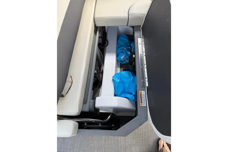 Slide: The Image of Storage compartment in 2023 Starcraft EXS 3 Q boat with blue bags inside. - 30