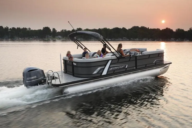 Slide: The Image of Manufacturer Provided Image: 2023 Starcraft EXS 3 Q pontoon boat cruising on a lake at sunset. - 4