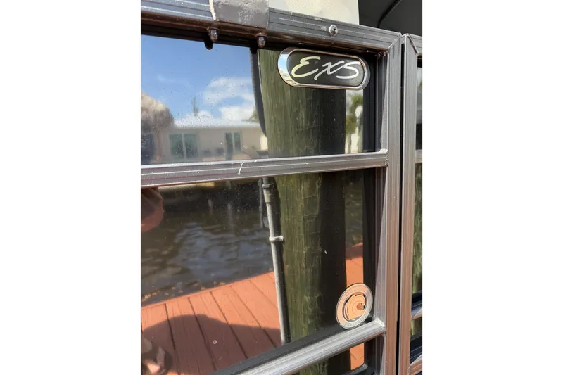 Slide: The Image of Close-up of 2023 Starcraft EXS 3 Q boat window with logo and water reflection. - 43