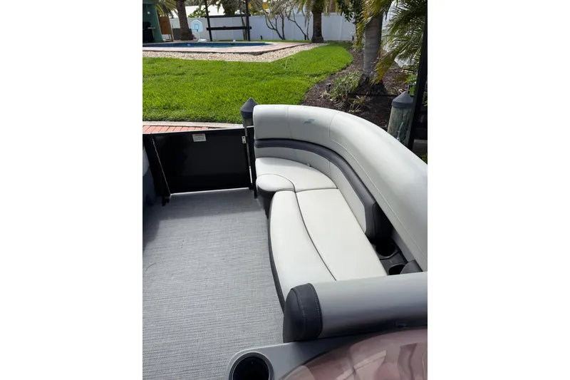Slide: The Image of 2023 Starcraft EXS 3 Q boat interior with curved seating and lush outdoor view. - 44