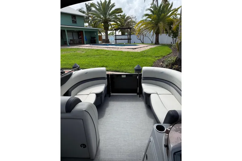Slide: The Image of Interior of 2023 Starcraft EXS 3 Q boat with plush seating, overlooking a lush backyard. - 45