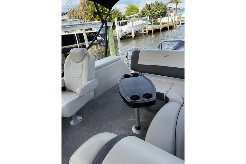 Slide: The Image of 2023 Starcraft EXS 3 Q boat interior with seating and table, docked by the water. - 47