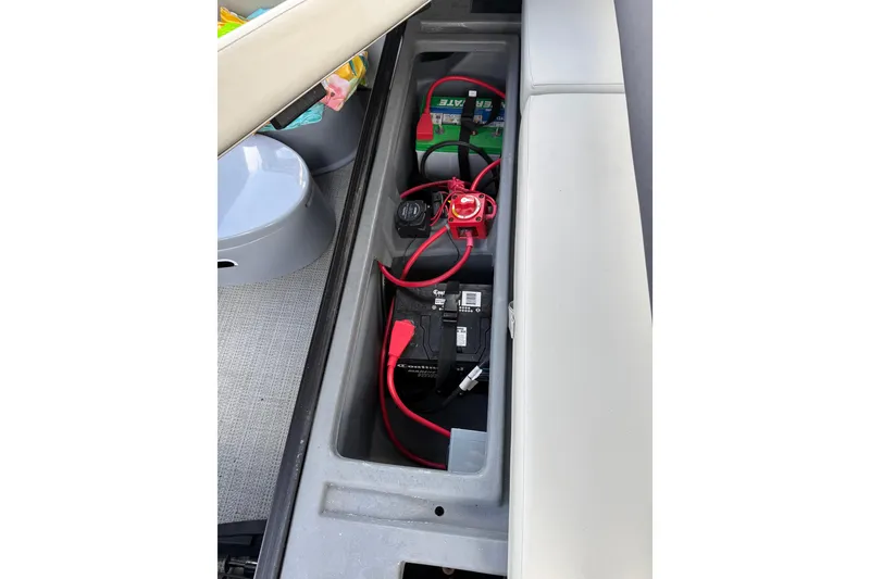 Slide: The Image of 2023 Starcraft EXS 3 Q boat battery compartment with wiring and storage. - 48