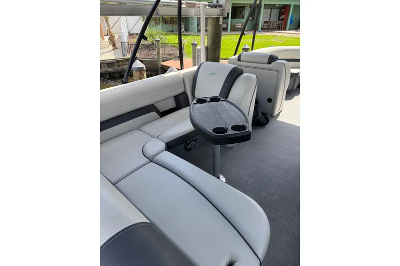 Slide: The Image of 2023 Starcraft EXS 3 Q boat interior with gray seating and cup holder table. - 9