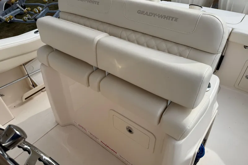 Slide: The Image of 2024 Grady-White Canyon 271 boat seating with white upholstery and storage compartment. - 12