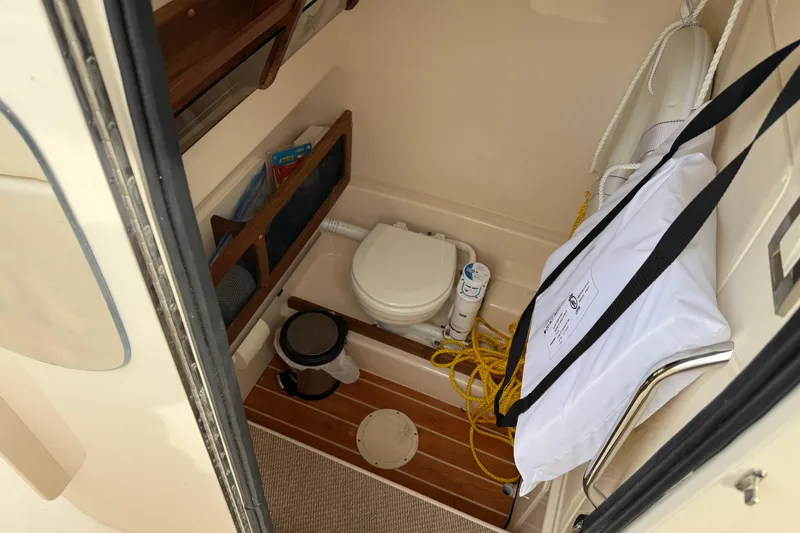 Slide: The Image of 2024 Grady-White Canyon 271 boat interior with compact bathroom amenities. - 13