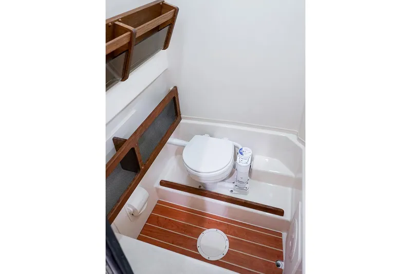 Slide: The Image of Manufacturer Provided Image: 2024 Grady-White Canyon 271 boat bathroom with wooden accents and modern toilet. - 19