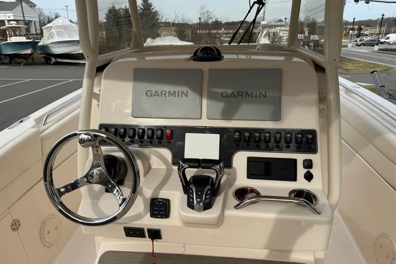 Slide: The Image of 2024 Grady-White Canyon 271 boat dashboard with Garmin navigation displays. - 6