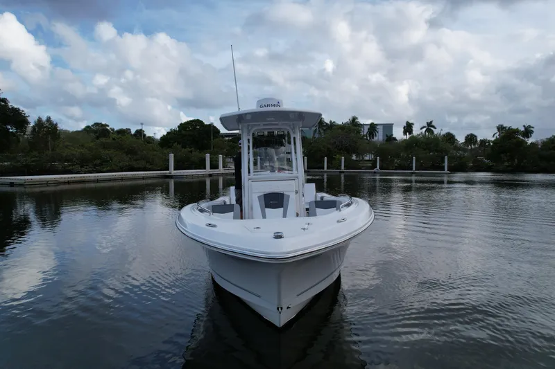 Slide: The Image of 2021 Robalo R230 Center Console boat on calm water under cloudy sky. - 11