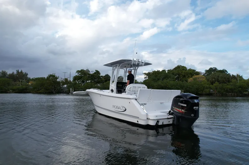 Slide: The Image of 2021 Robalo R230 Center Console boat on calm water with Yamaha outboard motor. - 13