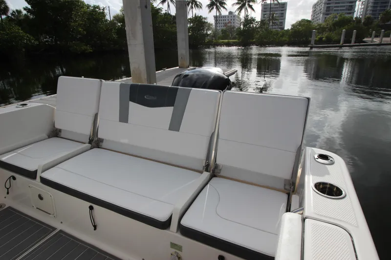 Slide: The Image of 2021 Robalo R230 Center Console boat with white seating, docked by calm waters. - 25