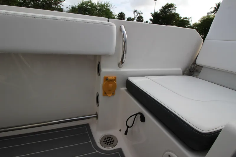 Slide: The Image of Interior seating of 2021 Robalo R230 Center Console boat, featuring white upholstery and stainless steel accents. - 28