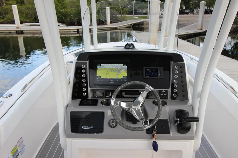 Slide: The Image of 2021 Robalo R230 Center Console boat dashboard with navigation system and steering wheel. - 30