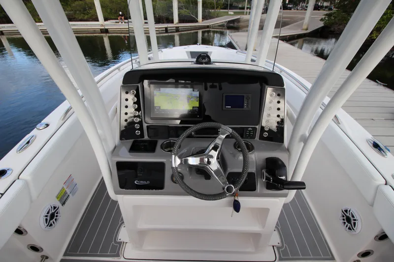 Slide: The Image of 2021 Robalo R230 Center Console boat dashboard with steering wheel and navigation system. - 33