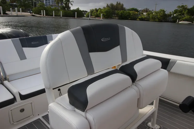 Slide: The Image of 2021 Robalo R230 Center Console boat interior with cushioned seating by the water. - 36