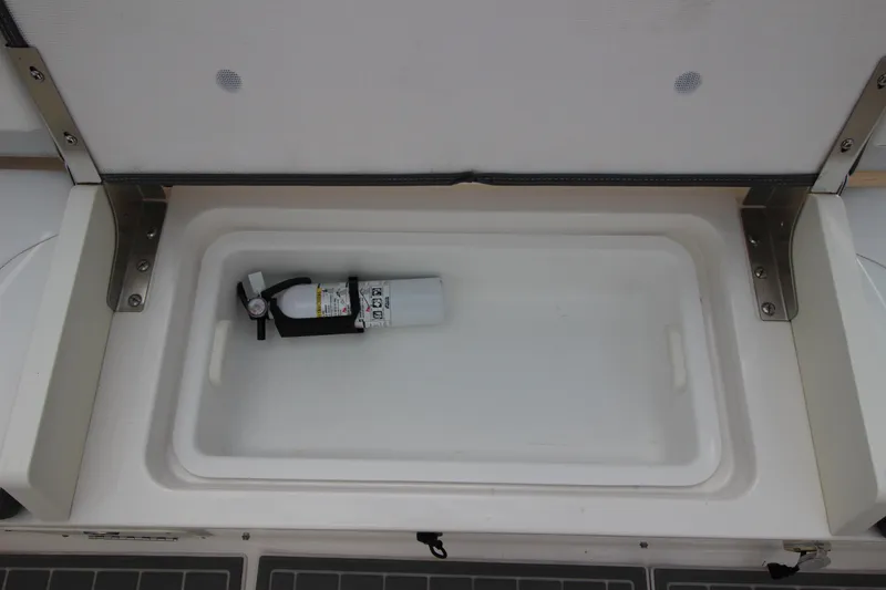 Slide: The Image of Storage compartment with fire extinguisher on 2021 Robalo R230 Center Console boat. - 44