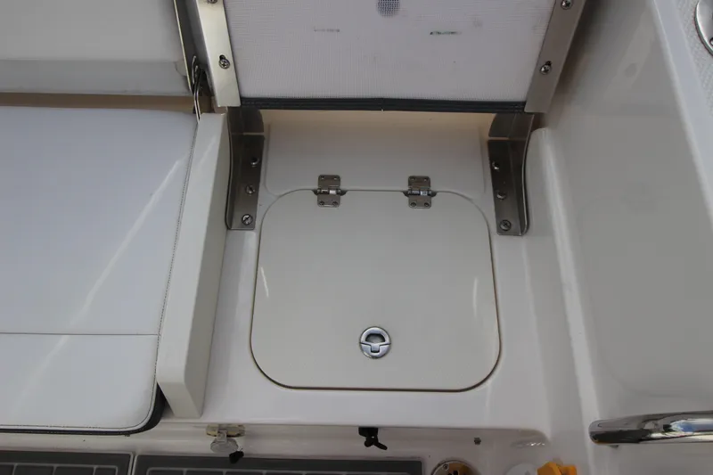Slide: The Image of 2021 Robalo R230 Center Console boat storage compartment with secure latch. - 45