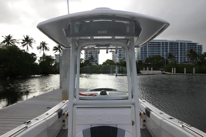 Slide: The Image of 2021 Robalo R230 Center Console boat docked near waterfront buildings and palm trees. - 51