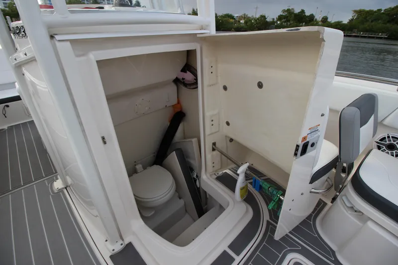 Slide: The Image of 2021 Robalo R230 Center Console boat with open storage compartment and toilet. - 54