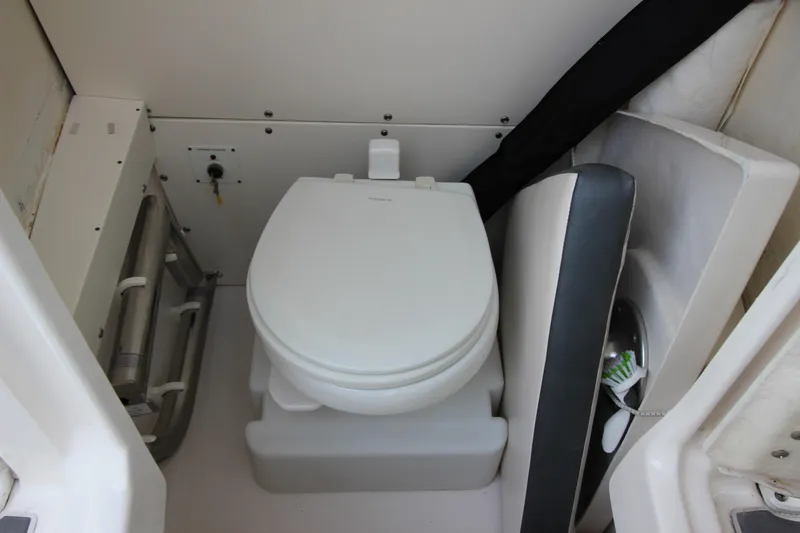 Slide: The Image of 2021 Robalo R230 Center Console boat interior with compact marine toilet. - 55