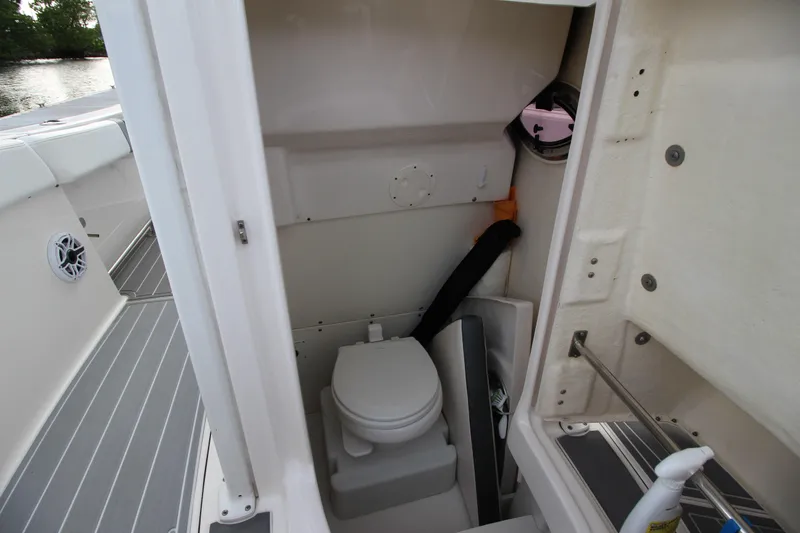 Slide: The Image of 2021 Robalo R230 Center Console boat interior with compact marine toilet. - 56