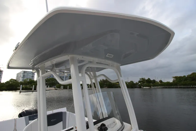 Slide: The Image of 2021 Robalo R230 Center Console boat with T-top on a calm waterway. - 59