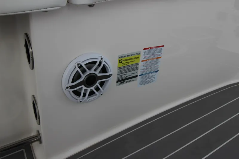 Slide: The Image of 2021 Robalo R230 Center Console boat interior with speaker and capacity label. - 65