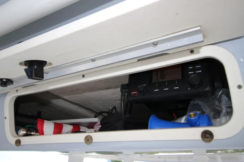 Slide: The Image of Storage compartment in 2021 Robalo R230 Center Console boat with radio and accessories. - 67