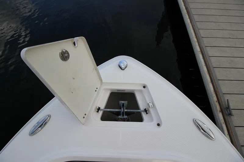 Slide: The Image of 2021 Robalo R230 Center Console boat anchor compartment open at dock. - 72