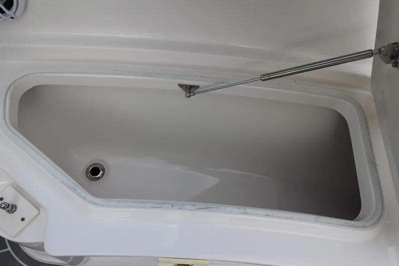 Slide: The Image of 2021 Robalo R230 Center Console storage compartment with open lid and hydraulic support. - 76