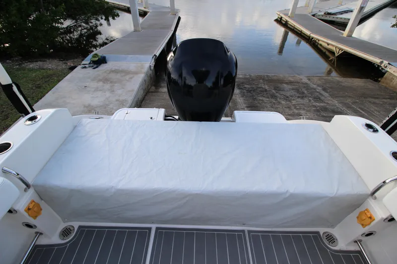 Slide: The Image of 2021 Robalo R230 Center Console boat at dock, featuring covered seating and outboard motor. - 86