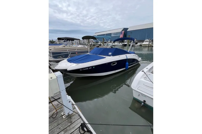 The Image of 2016 Chaparral 224 Sunesta boat docked at marina with blue cover. - 1