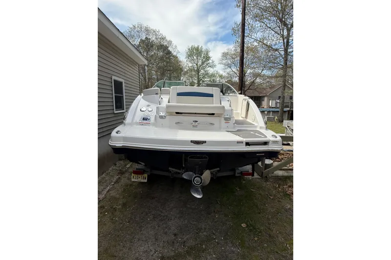 Slide: The Image of 2016 Chaparral 224 Sunesta boat parked outdoors, rear view with trees in background. - 11