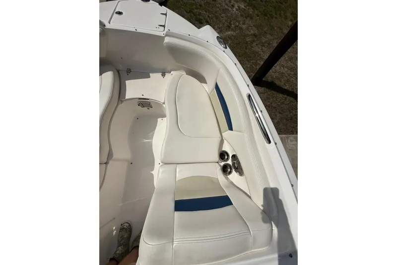 Slide: The Image of Interior seating of a 2016 Chaparral 224 Sunesta boat, featuring white and blue upholstery. - 25