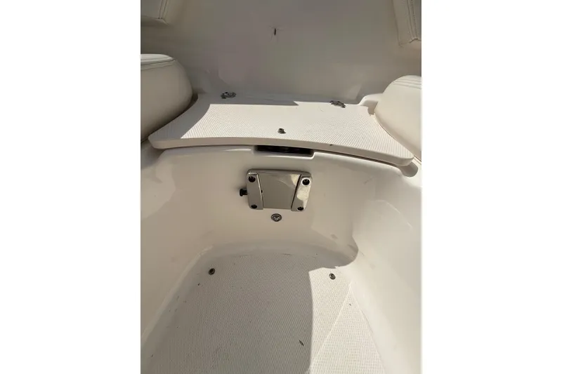 Slide: The Image of 2016 Chaparral 224 Sunesta boat interior with white seating and storage compartment. - 30