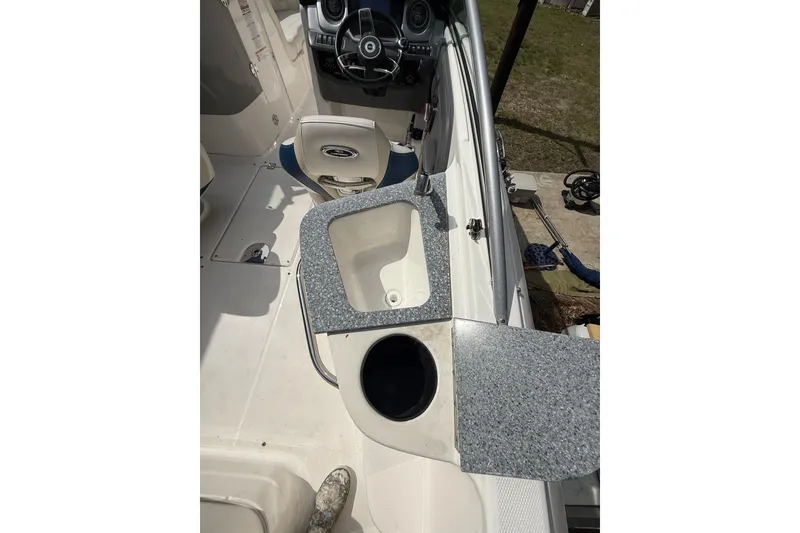 Slide: The Image of 2016 Chaparral 224 Sunesta boat interior with steering wheel and sink area. - 47