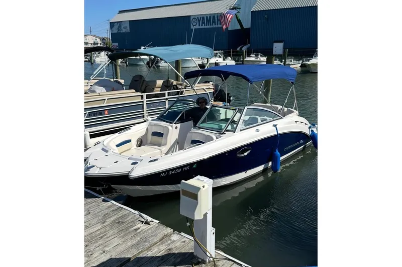 Slide: The Image of 2016 Chaparral 224 Sunesta boat docked at marina with blue canopy. - 5
