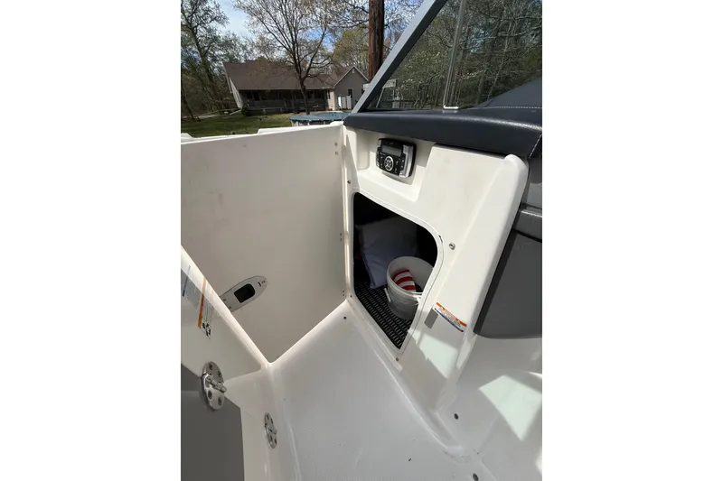 Slide: The Image of 2016 Chaparral 224 Sunesta boat interior storage compartment with open door. - 57