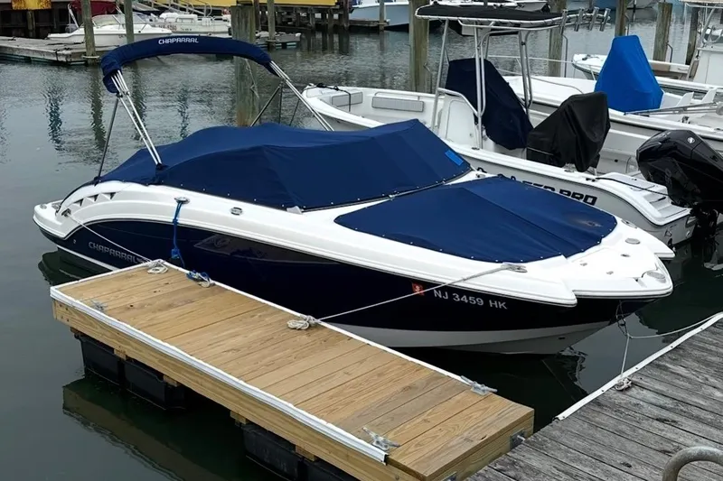 Slide: The Image of 2016 Chaparral 224 Sunesta boat docked with blue covers in a marina. - 6