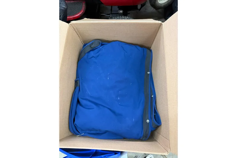 Slide: The Image of Cardboard box containing a folded blue boat cover for 2016 Chaparral 224 Sunesta. - 63
