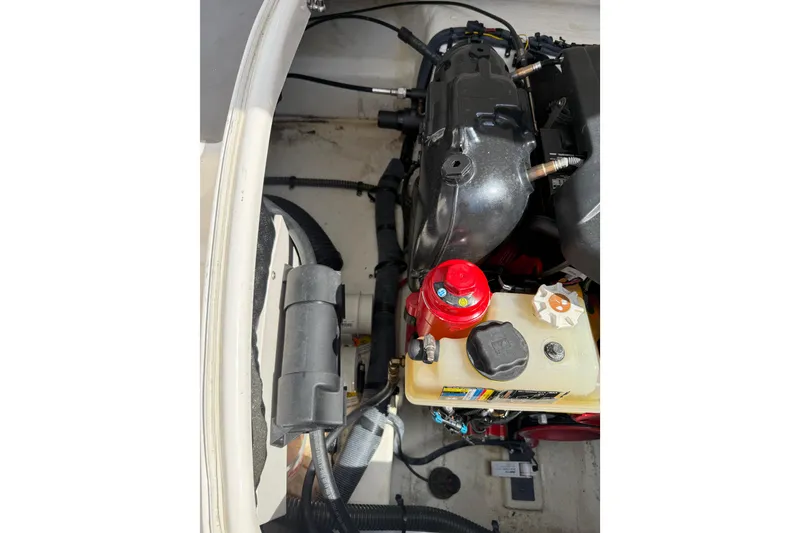 Slide: The Image of Engine compartment of a 2016 Chaparral 224 Sunesta boat, showing various components and hoses. - 67