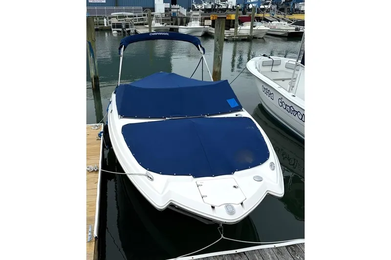 Slide: The Image of 2016 Chaparral 224 Sunesta boat docked with blue covers in a marina. - 7
