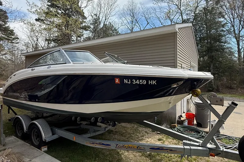 Slide: The Image of 2016 Chaparral 224 Sunesta boat on trailer near garage, surrounded by trees. - 9