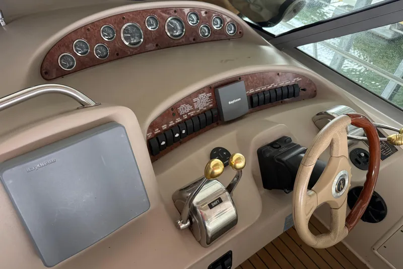 Slide: The Image of 2001 Sea Ray 340 Sundancer helm with gauges, steering wheel, and Raytheon equipment. - 11