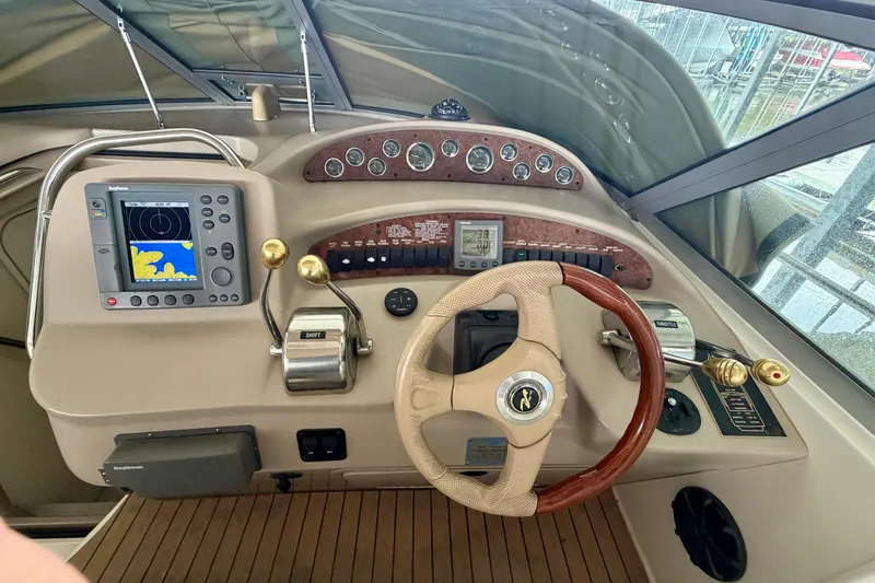 Slide: The Image of 2001 Sea Ray 340 Sundancer helm with navigation controls and wooden steering wheel. - 12