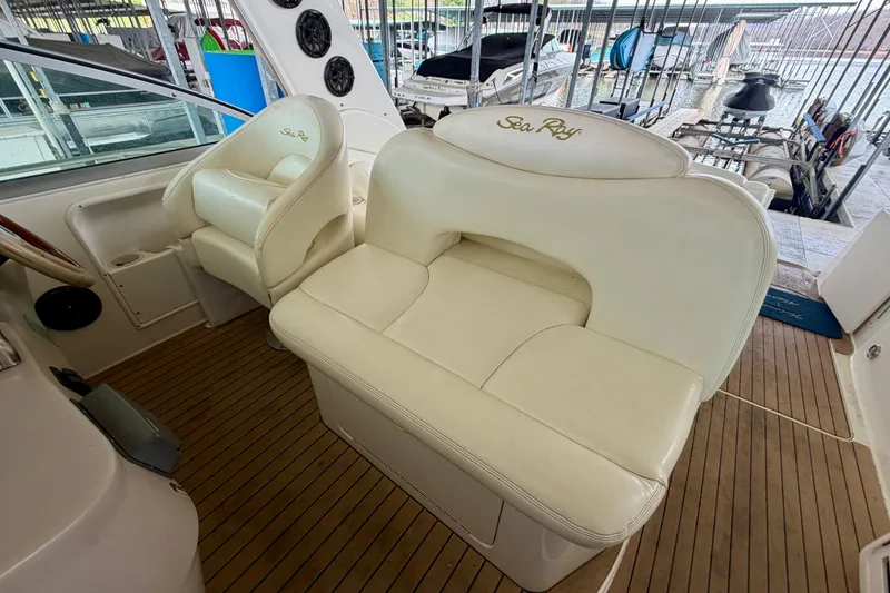 Slide: The Image of 2001 Sea Ray 340 Sundancer cockpit with white seating and wood flooring. - 14